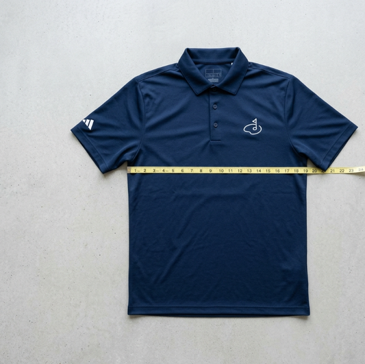 Size M Fairway Polo laid flat with a tape measure across the chest showing a 54.2 cm flat width