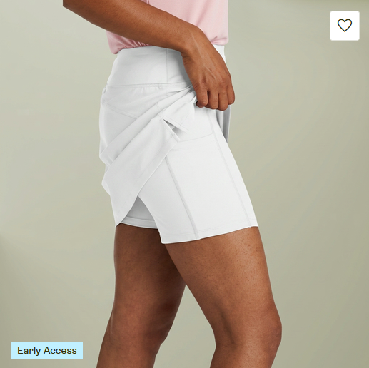White sports skort with built-in shorts, shown with the outer skirt lifted